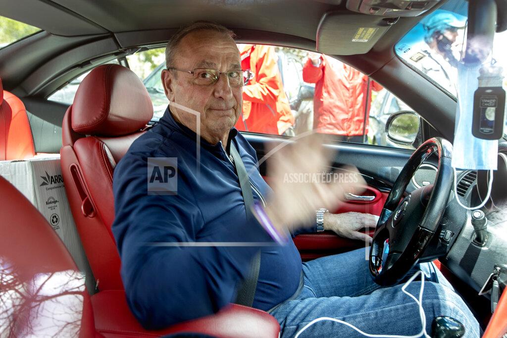 Robert F. Bukaty Former Gov. Paul LePage, waves before leaving a rally against the executive orders by Gov. Janet Mills to keep some Maine businesses closed to help prevent the spread of coronavirus, Saturday, May 16, 2020, in Augusta, Maine. LePage, now a resident of Florida, stayed in his car parked near the rally. A speaker at the event said the former governor was quarantining. (AP Photo/Robert F. Bukaty)