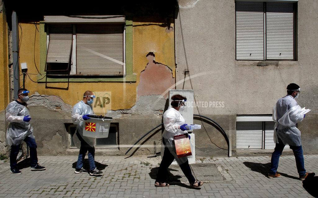 Boris Grdanoski Members of a special election team with a ballot box and voting material make their way to voters who have tested positive for COVID-19 or are in self-isolation, in Skopje, North Macedonia, Monday, July 13, 2020. North Macedonia holds its first parliamentary election under its new country name this week, with voters heading to the polls during an alarming spike of coronavirus cases in the small Balkan nation. Opinion polls in the run-up to Wednesday’s vote indicate a close race between coalitions led by the Social Democrats and the center-right opposition VMRO-DPMNE party. (AP Photo/Boris Grdanoski)