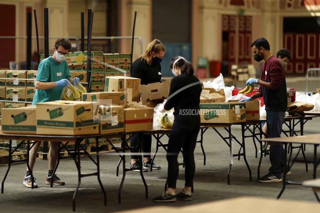 Matt Dunham Volunteers for the Edible London food project remove the plastic packaging and check the quality of donated bananas to be put in food packs and delivered to residents who need it in the Haringey Council area, at a hub setup as a result of coronavirus inside the Alexandra Palace venue, in north London, Tuesday, April 21, 2020. The highly contagious COVID-19 coronavirus has impacted on nations around the globe, many imposing self isolation and exercising social distancing when people move from their homes. (AP Photo/Matt Dunham)