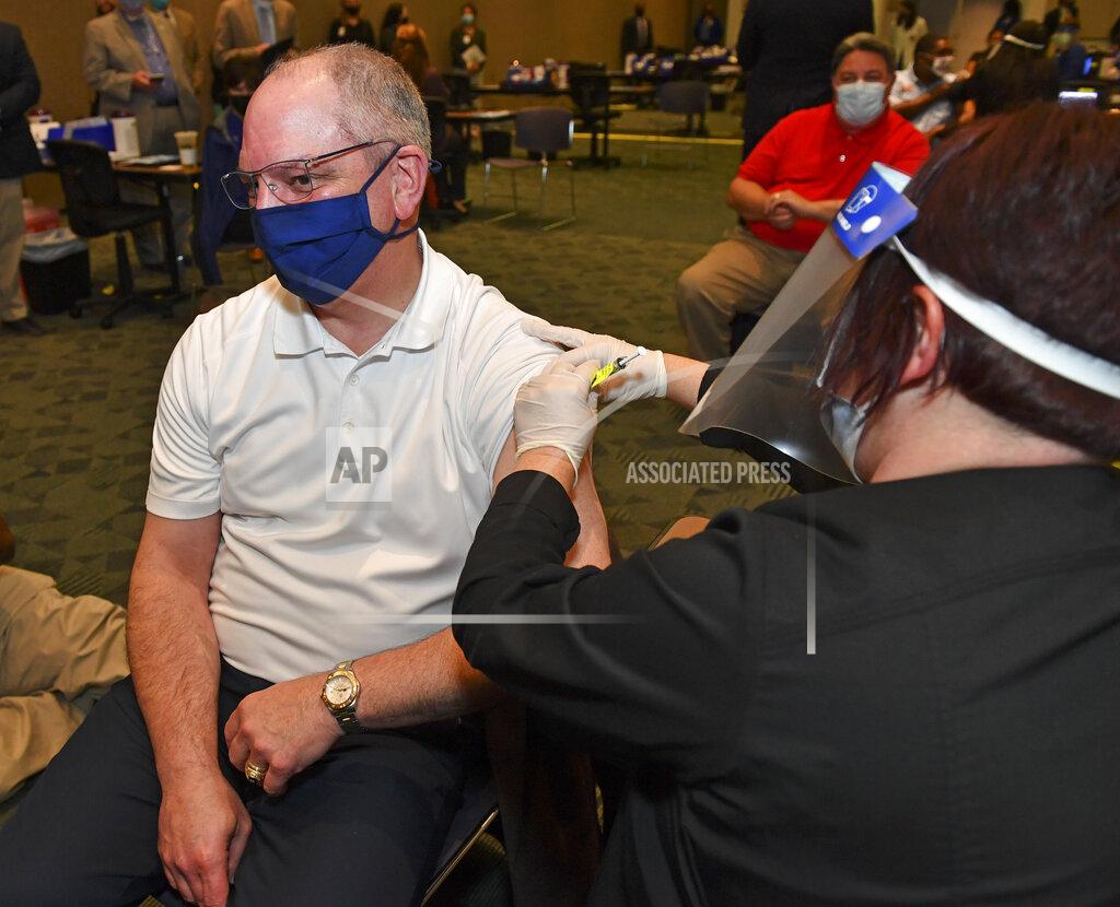 Louisiana Gov. John Bel Edwards receives the Pfizer-BioNTech COVID-19 vaccine, administered by OLOL clinical supervisor Lori Koonce at the C.B. Pennington, Jr. Building & Conference Center, Tuesday, Feb. 9, 2021, on the campus of the Pennington Biomedical Research Center in Baton Rouge, La. (Hilary Scheinuk/The Advocate via AP)