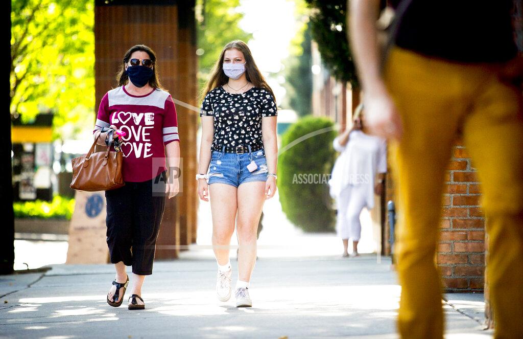 Isaac Hale Rebecca Layton and her daughter Delaney Layton, both of Vancouver, Washington, wear face masks as they walk in downtown Provo, Utah, on Thursday, Aug. 27, 2020. (Isaac Hale/The Daily Herald via AP)