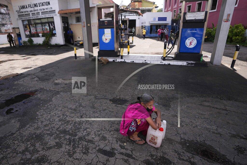 Eranga Jayawardena A Sri Lankan woman waits in a deserted gas station, hoping to buy kerosene oil for cooking in Colombo, Sri Lanka, Thursday, May 26, 2022. Sri Lankans for months have been forced to stand in long lines to buy scarce essentials, with many returning home empty-handed. There is a severe shortage of many goods, from food, cooking gas, medicine and fuel to toilet paper and matchsticks. (AP Photo/Eranga Jayawardena)