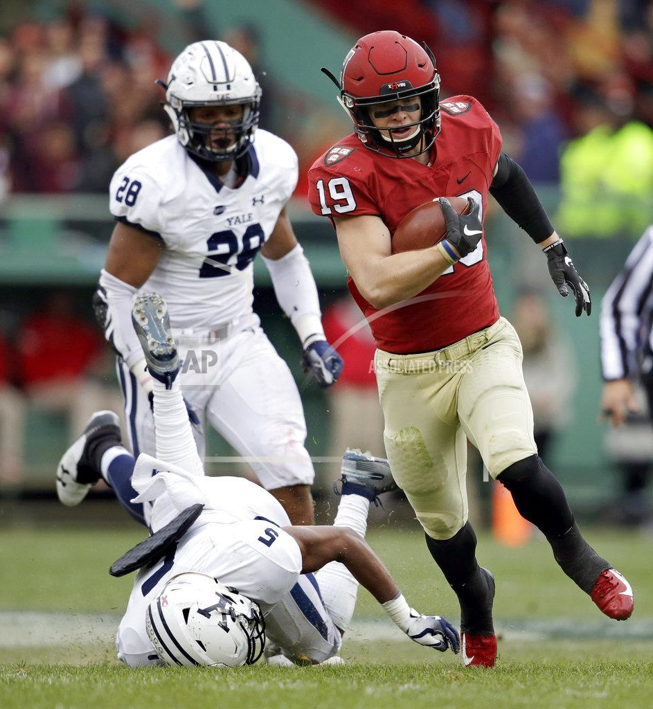 Charles Krupa Harvard wide receiver Tyler Adams (19) breaks free as Yale defensive back Miles Oldacre, left, face plants into the turf on a touchdown run during the first half of an NCAA college football game at Fenway Park in Boston, Saturday, Nov. 17, 2018. At rear is Yale defensive end Christian Sampleton (28). (AP Photo/Charles Krupa)