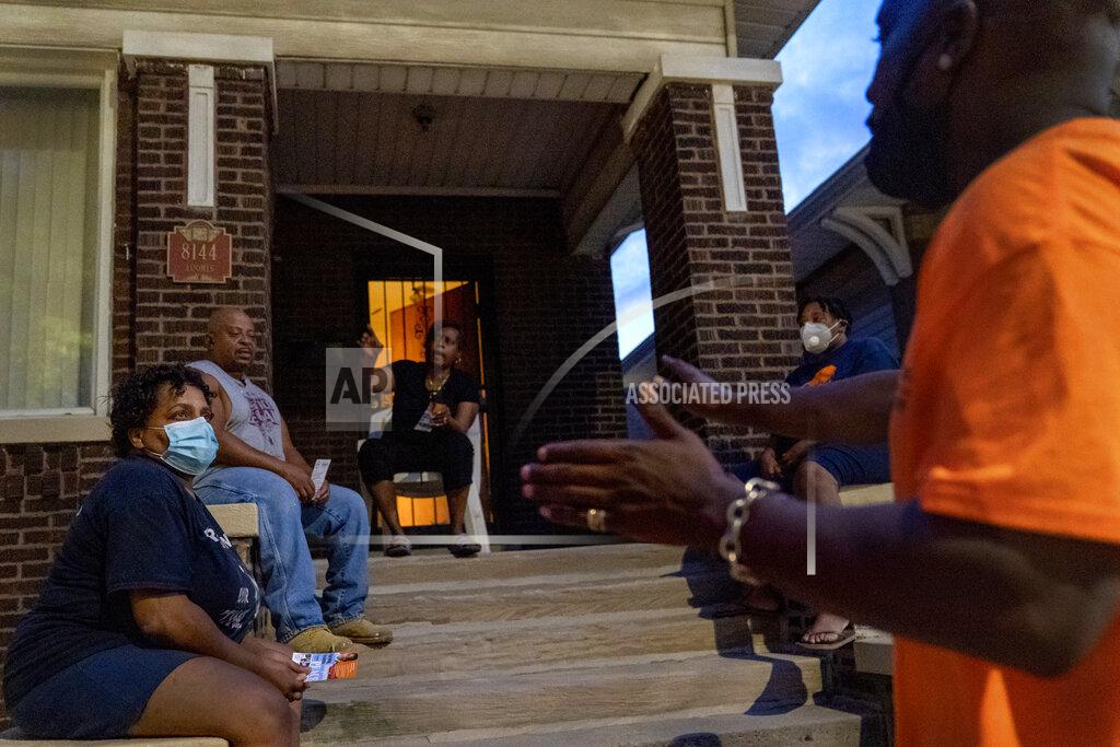 David Goldman Demetrius Mingo, right, an outreach worker with the Target Area Development Corporation, a nonprofit that addresses stubborn local problems, talks with residents while making rounds looking to mediate conflicts in the Auburn Gresham neighborhood in Chicago, Saturday, Aug. 22, 2020. The group has also walked the streets to warn one segment of the population, victims and perpetrators of gun violence, of the dangers of a virus they could unwittingly pass on to their families. (AP Photo/David Goldman)