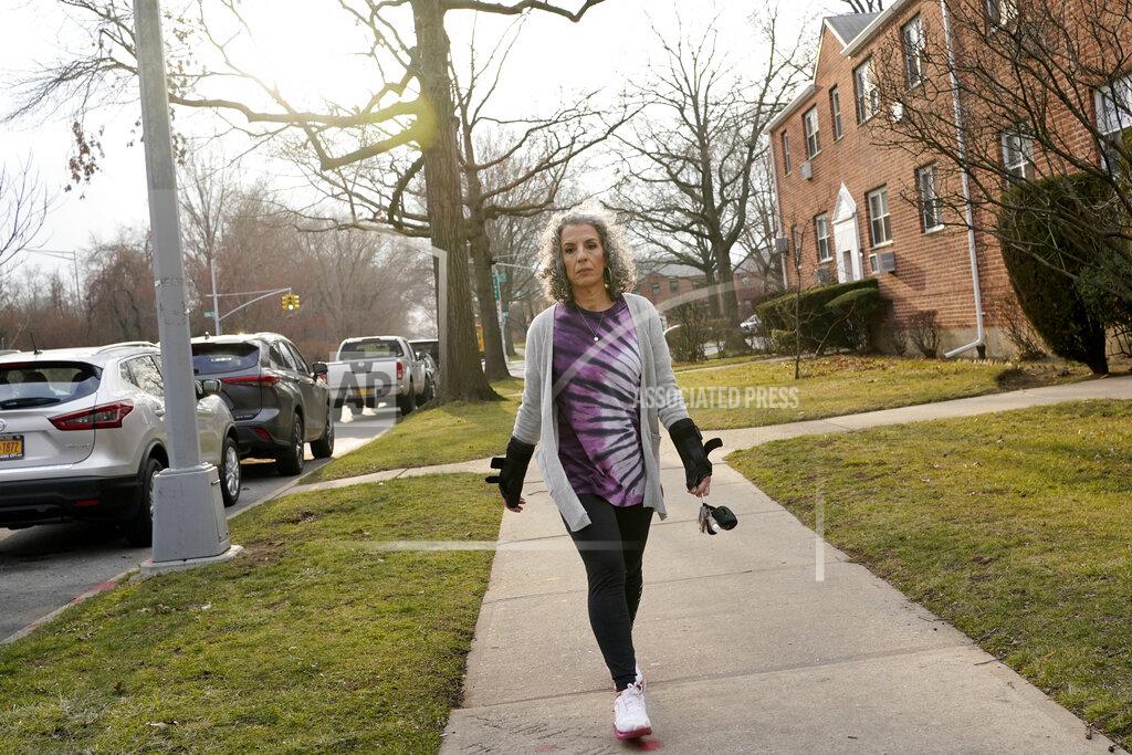 Seth Wenig Catherine Busa takes a walk around her neighborhood as part of her recovery from COVID-19 in New York, Wednesday, Jan. 13, 2021. The 54-year-old New York City school secretary didn’t have any underlying health problems when she caught the coronavirus in March and recovered at her Queens home. But some symptoms lingered. After eights months of suffering, she made her way to Jamaica Hospital Medical Center — to a clinic specifically for post-COVID-19 care. (AP Photo/Seth Wenig)