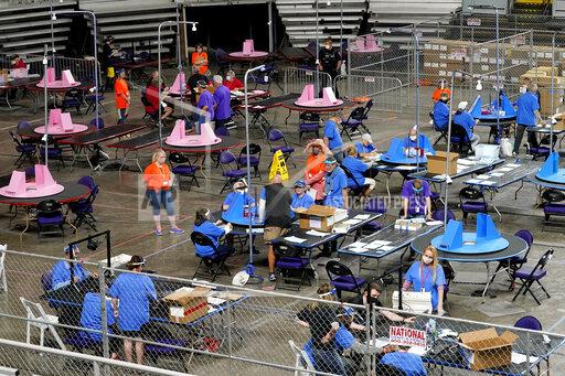 FILE - In this May 6, 2021, file photo, Maricopa County ballots cast in the 2020 general election are examined and recounted by contractors working for Florida-based company, Cyber Ninjas at Veterans Memorial Coliseum in Phoenix. Ron Watkins, a prolific promoter of false conspiracies about the 2020 election who is closely tied to the QAnon movement, says he's running for Congress as a Republican in Arizona. (AP Photo/Matt York, Pool)