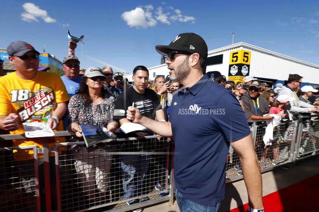 Driver Jimmie Johnson acknowledges fans as he walks to the drivers' meeting prior to a NASCAR Cup Series auto race at Phoenix Raceway, Sunday, March 8, 2020, in Avondale, Ariz. (AP Photo/Ralph Freso)