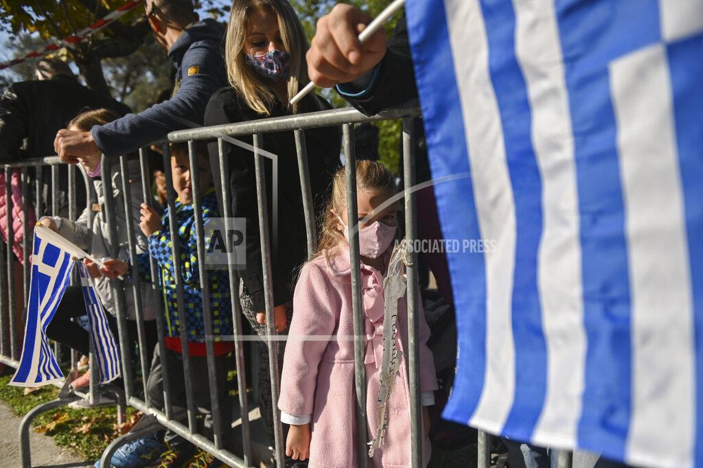 Giannis Papanikos People watch the military parade at the northern port city of Thessaloniki, Greece, Thursday, Oct. 28, 2021 .The parade is held to celebrate Greece's refusal to align itself with a belligerent fascist Italy in 1940 and instead fight a much stronger opponent, a decision which dragged it into World War II and eventually led to a brutal occupation by Nazi Germany. (AP Photo/Giannis Papanikos)