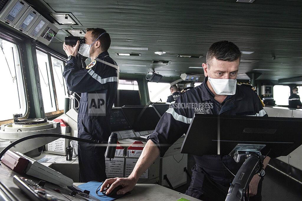 Y. Bisson This photo provided Saturday April 10, 2020 by the French Navy (Marine Nationale) shows sailors wearing face masks aboard the French aircraft carrier Charles de Gaulle, Thursday April 8, 2020 in the Atlantic Ocean. France's only aircraft carrier has confirmed 50 cases of the new virus aboard and is heading back to port. Three of those aboard the Charles de Gaulle with the virus have been flown to French hospitals for treatment, the French military said in a statement Friday .The new coronavirus causes mild or moderate symptoms for most people, but for some, especially older adults and people with existing health problems, it can cause more severe illness or death. (Y. Bisson/Marine Nationale via AP)