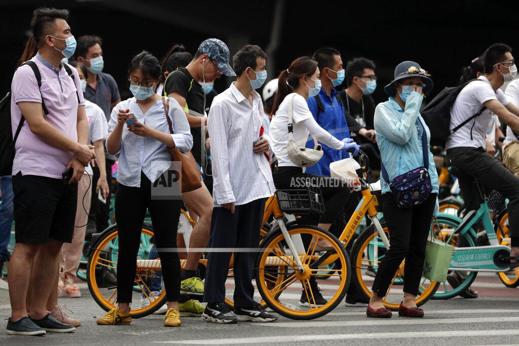 Andy Wong People wearing protective face masks to help curb the spread of the new coronavirus wait to cross a street in Beijing, Monday, June 22, 2020. A Beijing government spokesperson said the city has contained the momentum of a recent coronavirus outbreak that has infected a few hundreds of people, after the number of daily new cases fell to single digits. (AP Photo/Andy Wong)