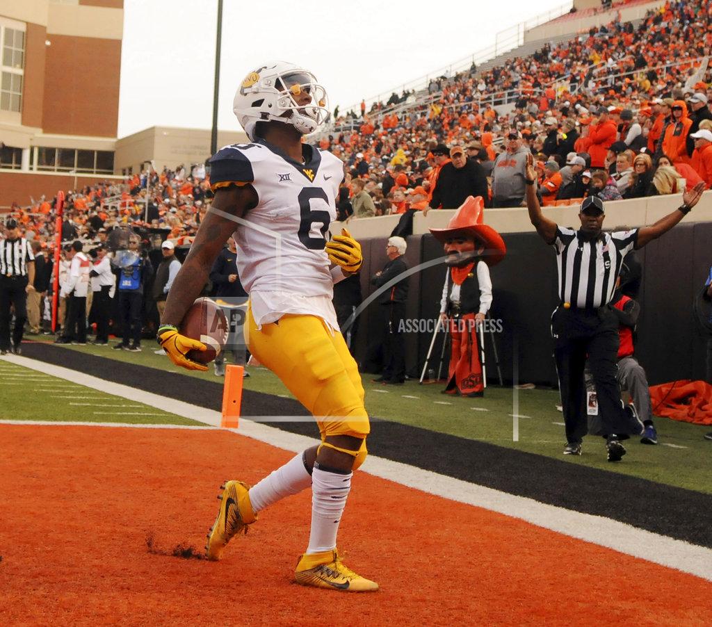 Brody Schmidt West Virginia running back Kennedy McKoy scores a touchdown during the first half of an NCAA college football game in Stillwater, Okla., Saturday, Nov. 17, 2018. McKoy had 2 touchdown in the 41-45 loss to Oklahoma State. (AP Photo/Brody Schmidt)