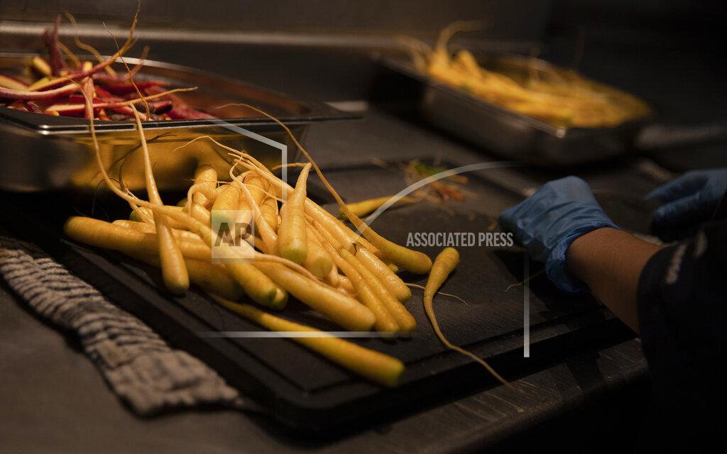 Virginia Mayo A prep chef peels carrots as she works on nearly 600 take-away orders at Sergio Herman's Le Pristine restaurant in Antwerp, Belgium, Friday, Nov. 6, 2020. Of all the many challenges the pandemic throws up for all kinds of professions, this one has been particularly tough: How to put a three-star chef into a takeout box. (AP Photo/Virginia Mayo)