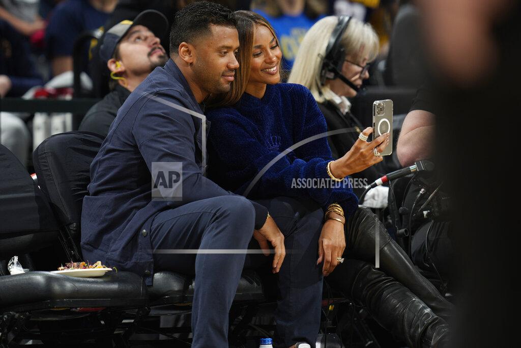 David Zalubowski Denver Broncos quarterback Russell Wilson, left, poses for a photo with his wife, rap star Ciara, as they sit courtside in the first half of Game 4 of an NBA basketball first-round Western Conference playoff series between the Golden State Warriors and Denver Nuggets, Sunday, April 24, 2022, in Denver. (AP Photo/David Zalubowski)