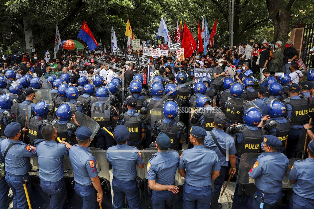 Basilio Sepe Police block activists protesting the upcoming proclamation of presidential frontrunner Ferdinand "Bongbong" Marcos and running mate Sara Duterte, daughter of the current president, during a rally at the Commission on Human Rights in Quezon City, Metro Manila, Marcos Jr. continues to lead in the official canvassing of votes. (AP Photo/Basilio Sepe)