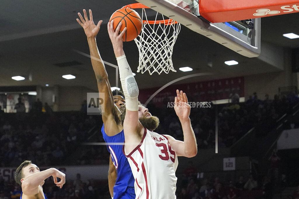Sue Ogrocki Oklahoma forward Tanner Groves (35) shoots in front of Kansas guard Ochai Agbaji, center, in the second half of an NCAA college basketball game Tuesday, Jan. 18, 2022, in Norman, Okla. (AP Photo/Sue Ogrocki)