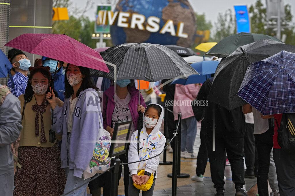 Andy Wong Visitors line-up to enter a merchandise store at the Universal Studios Beijing in Beijing, Monday, Sept. 20, 2021. Thousands of people brave the rain visit to the newest location of the global brand of theme parks which officially opens on Monday. (AP Photo/Andy Wong)