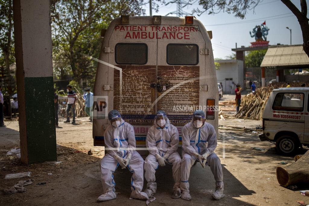 Altaf Qadri FILE - In this April 24, 2021, file photo, exhausted workers who carried the dead for cremation sit on the rear step of an ambulance in New Delhi, India. As deaths mount and a vaccine rollout falters badly, Prime Minister Narendra Modi has pushed much of the responsibility for fighting the outbreak onto unprepared and poorly equipped state governments. The crisis has badly dented Modi’s carefully cultivated image as an able technocrat. (AP Photo/Altaf Qadri, File)