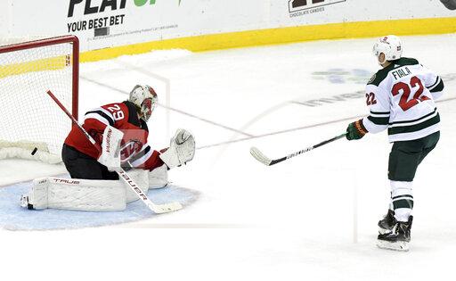 Minnesota Wild left wing Kevin Fiala (22) scores a goal against New Jersey Devils goaltender Mackenzie Blackwood (29) in a shootout during an NHL hockey game Wednesday, Nov.24, 2021, in Newark, N.J. The Wild defeated the Devils 3-2 in a shootout. (AP Photo/Bill Kostroun)