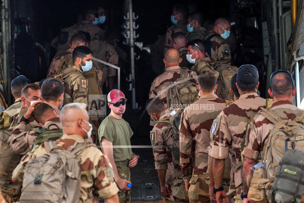 Uncredited French Barkhane force soldiers who wrapped up a four-month tour of duty in the Sahel board a US Air Force C130 transport plane, leave their base in Gao, Mali, Wednesday June 9, 2021. France has suspended joint military operations with Malian forces until the junta led by Col. Assimi Goita, who retook control of Mali's transitional government May 24, complies with international demands to restore civilian rule. (AP Photo/Jerome Delay)