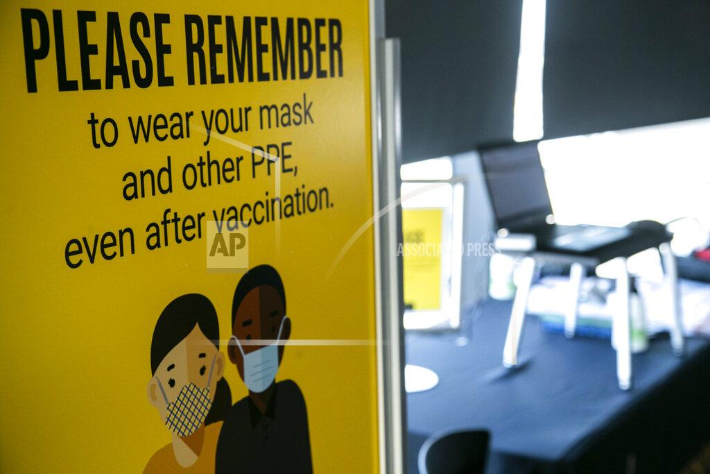 Joseph Cress A sign reminds patients to continue to wear protective equipment even after receiving their Pfizer-BioNTech COVID-19 vaccine at the hospital, Monday, Dec. 14, 2020, on the 12th floor of the University of Iowa Stead Family Children's Hospital in Iowa City, Iowa. (Joseph Cress/Iowa City Press-Citizen via AP)