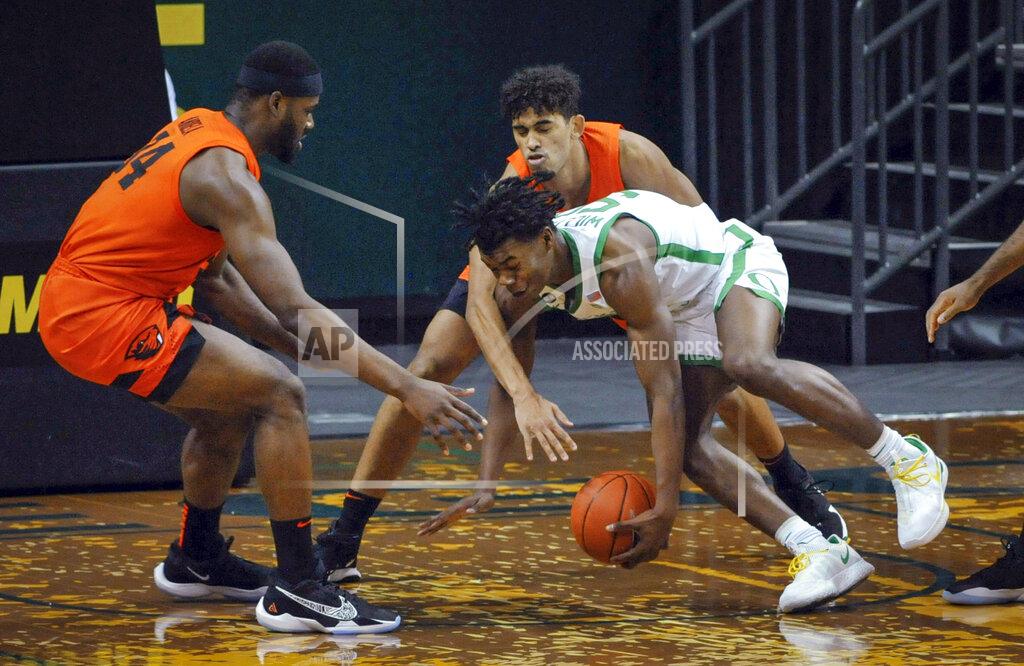 Andy Nelson Oregon State forward Rodrigue Andela, left, and Julien Franklin defend against Oregon forward Eric Williams Jr. during the first half of an NCAA college basketball game Saturday, Jan. 23, 2021, in Eugene, Ore. (AP Photo/Andy Nelson)
