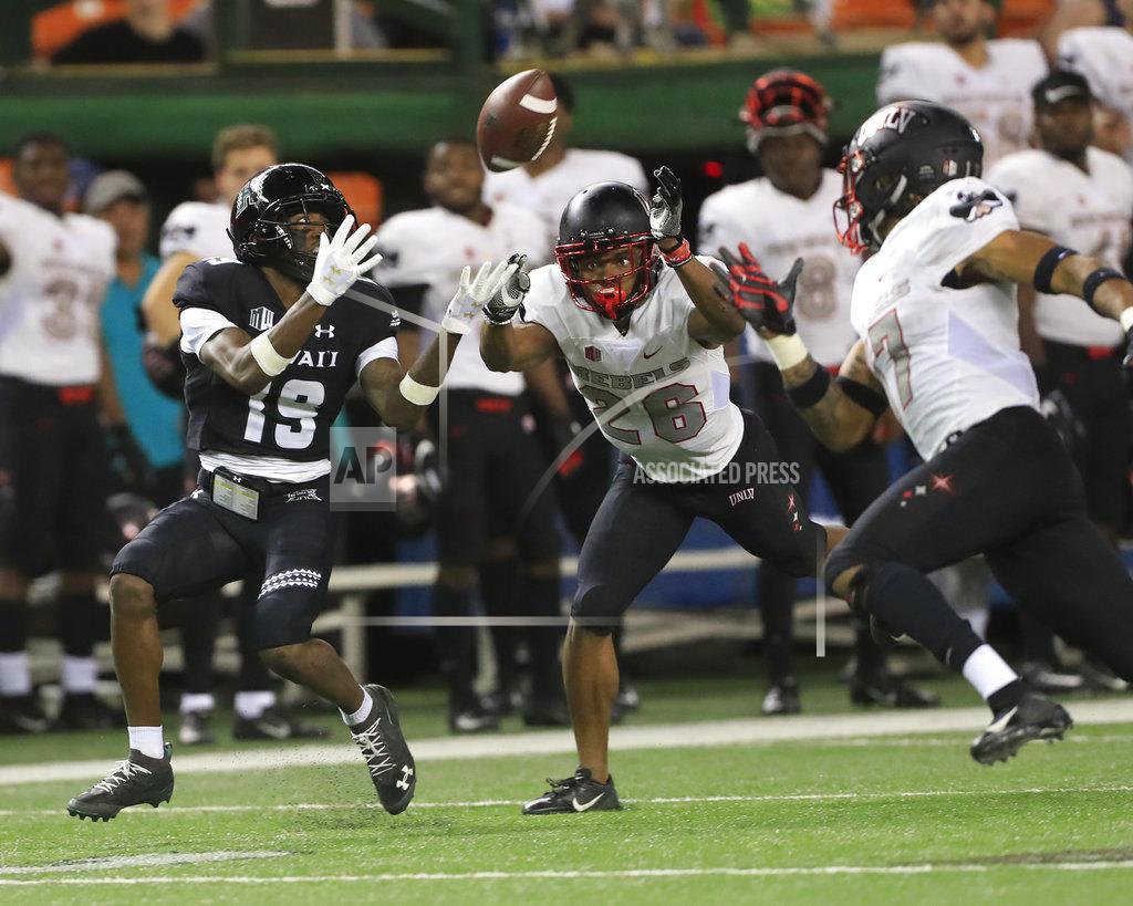 Marco Garcia Hawaii wide receiver JoJo Ward (19) makes a catch over UNLV defensive back Jocquez Kalili (26) and defensive back Evan Austrie (17) during the fourth quarter of an NCAA college football game, Saturday, Nov. 17, 2018, in Honolulu. Hawaii defeated UNLV 35-28. (AP Photo/Marco Garcia)