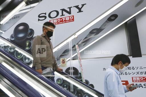 People ride past Sony branding at an electronics retail chain store in Tokyo, Wednesday, Oct. 13, 2021. Sony reported Thursday, Oct. 28, 2021, a 54% drop in its profit in the last quarter, mainly from a one-time tax-related gain that had inflated last year’s number, as the Japanese electronics and entertainment company managed to maintain results despite the coronavirus pandemic. (AP Photo/Koji Sasahara)