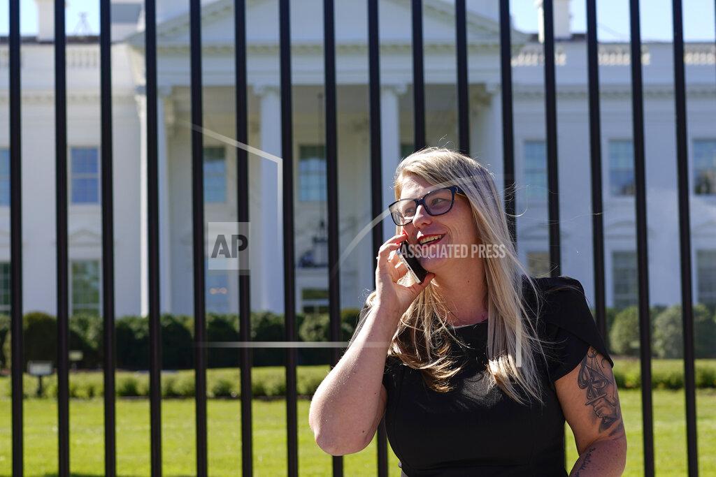 Carolyn Kaster Courtney Allen an organizer for Mobilize Recovery and on the settlement advisory council for the state of Maine, talks on her cell on Pennsylvania Avenue in front of the White House in Washington, Friday, Sept. 23, 2022. Allen and others are in Washington to meet with Doug Emhoff, husband of Vice President Kamala Harris, to give their recommendations for the distribution of the federal settlement money as billions of dollars in opioid lawsuit settlements are starting to flow to governments. (AP Photo/Carolyn Kaster)