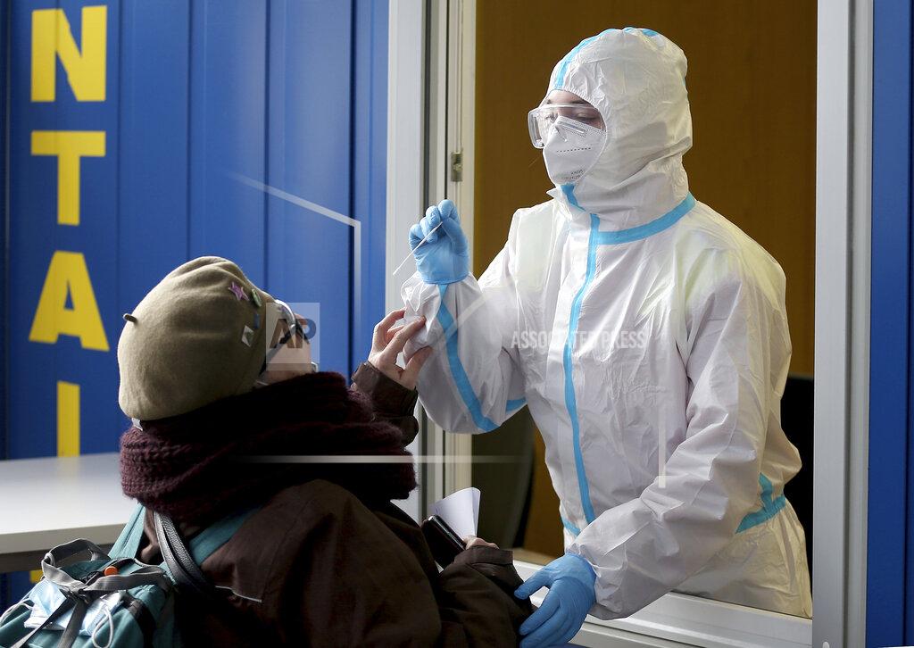 Ronald Zak A medical worker, right, tries to test woman for COVID-19 in a set up for rapid new coronavirus testing in Vienna, Austria, Monday, Nov. 30, 2020. The Austrian government has moved to restrict freedom of movement for people, in an effort to slow the onset of the COVID-19 disease and the spread of the coronavirus. (AP Photo/Ronald Zak)
