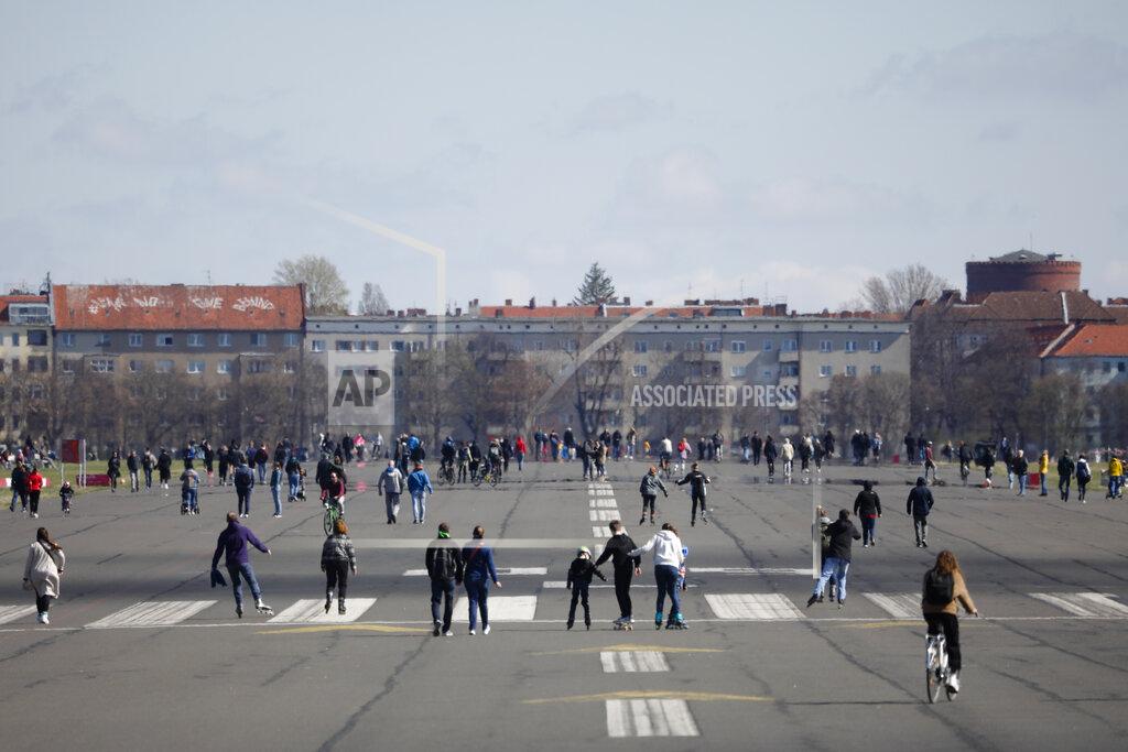 Markus Schreiber People walk on the runway of the former Tempelhof airport that is now a public park in Berlin, Germany, Friday, April 2, 2021. Due to the coronavirus pandemic only a limited number persons can meet together. (AP Photo/Markus Schreiber)