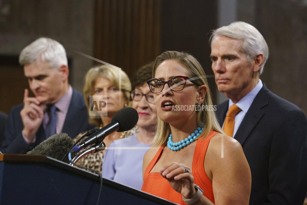 J. Scott Applewhite Sen. Kyrsten Sinema, D-Ariz., center, joined from left by, Sen. Bill Cassidy, R-La., Sen. Lisa Murkowski, R-Alaska, Sen. Susan Collins, R-Maine, and Sen. Rob Portman, R-Ohio, speak to reporters just after a vote to start work on a nearly $1 trillion bipartisan infrastructure package, at the Capitol in Washington, Wednesday, July 28, 2021. (AP Photo/J. Scott Applewhite)