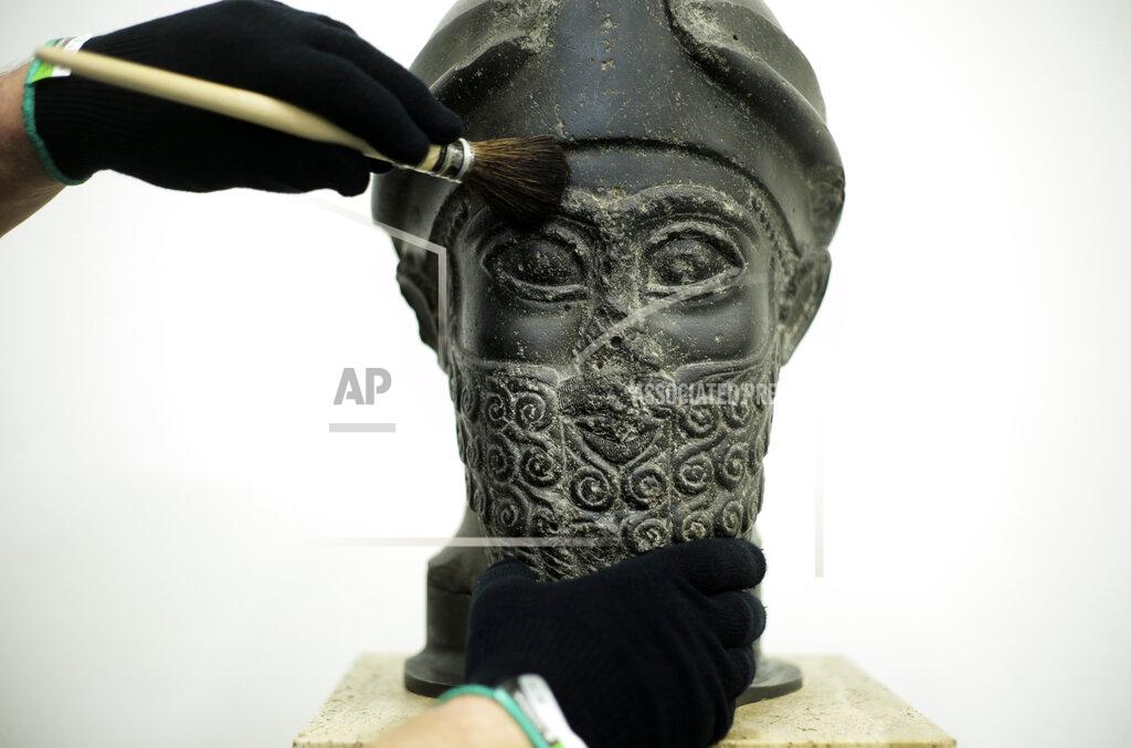 Markus Schreiber Stone restoration specialist Stefan Geismeier dusted off the black head of the statue of the Puzur-Ishtar of Mari at the Museum of the Ancient East in Berlin, Germany, Monday, March 15, 2021. Museums throughout Germany closed at the beginning of November as coronavirus cases increased. Under new regulations, some of the collections on Berlin's Museum Island, one of the city's cultural highlights and a UNESCO World Heritage site, are now allowed to re-open to visitors. (AP Photo/Markus Schreiber)