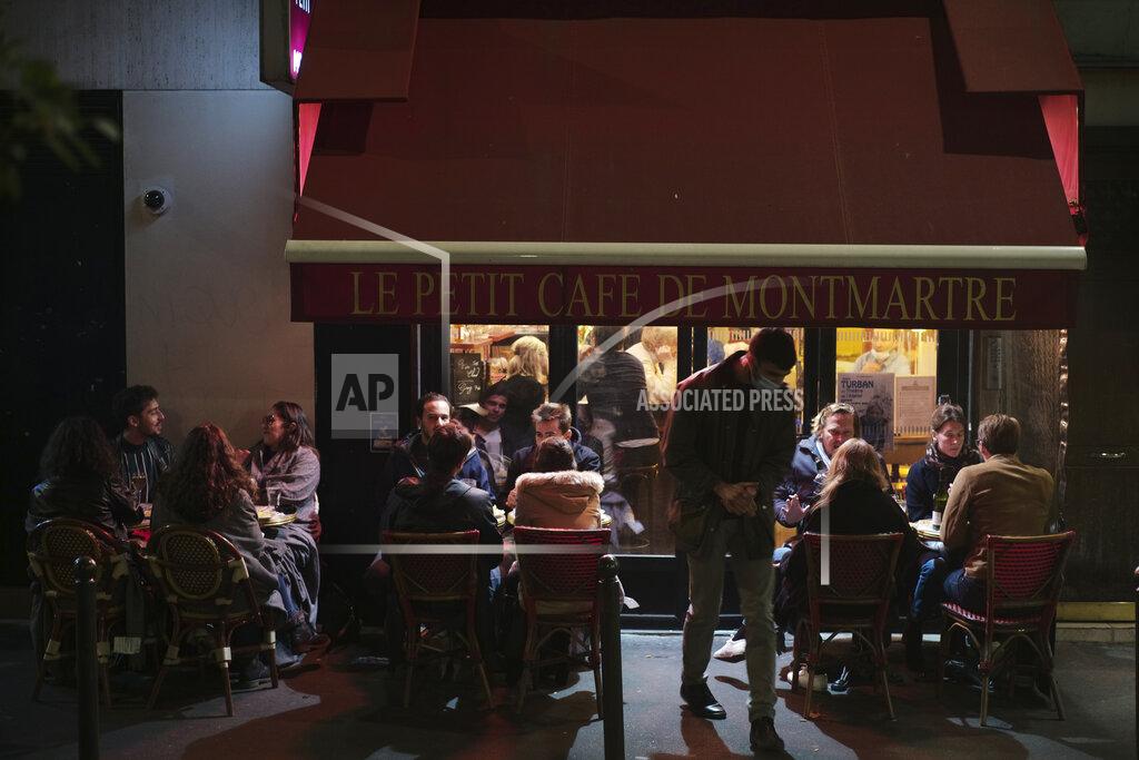 Lewis Joly FILE - In this Sept.26, 2020 file photo, people enjoy a drink in a cafe terrace in Paris. French authorities have placed the Paris region on maximum virus alert on Monday, banning festive gatherings and requiring all bars to close but allowing restaurants to remain open, as numbers of infections are rapidly increasing. (AP Photo/Lewis Joly, File)