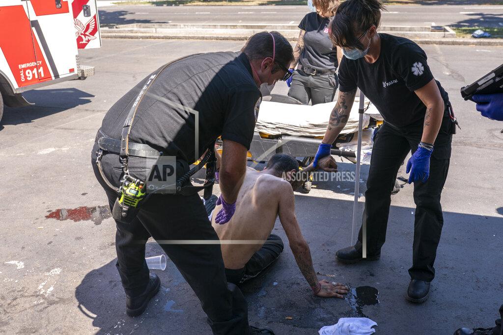 Nathan Howard FILE - In this Saturday, June 26, 2021 file photo, Salem Fire Department Capt. Matt Brozovich, left, and Falck Northwest ambulance personnel help treat a man experiencing heat exposure at a cooling center during a heat wave, in Salem, Ore. Scientists say there’s something different this year from the recent drumbeat of climate weirdness. This summer a lot of the places hit by weather disasters are not used to getting extremes and many of them are wealthier, which is different from the normal climate change victims. That includes unprecedented deadly flooding in Germany and Belgium, 116-degree heat records in Portland, Oregon and similar blistering temperatures in Canada, along with wildfires. Now Southern Europe is seeing scorching temperatures and out-of-control blazes too. And the summer of extremes is only getting started. Peak Atlantic hurricane and wildfire seasons in the United States are knocking at the door. (AP Photo/Nathan Howard, File)
