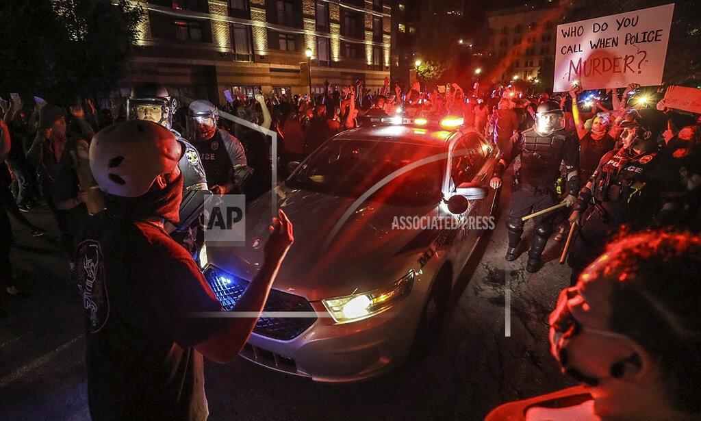 Police help to slowly move a patrol during a protest for Breonna Taylor, Thursday, May 28, 2020 in Louisville, Ky. Taylor, a black woman, was fatally shot by police in her home in March. (Michael Clevenger/Courier Journal via AP)