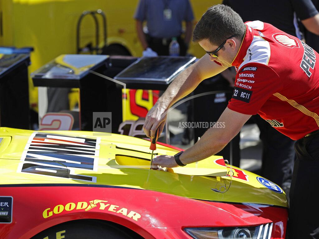 Chuck Burton A crew member tightens radiator exit duct openings in the hood of Joey Logano's race car before qualifying for Saturday's NASCAR All-Star Cup series auto race at Charlotte Motor Speedway in Concord, N.C., Friday, May 17, 2019. NASCAR will be using the 2019 All-Star race at Charlotte Motor Speedway as a research and development project on how to improve their cars and create better and more exciting competition for next year. (AP Photo/Chuck Burton)