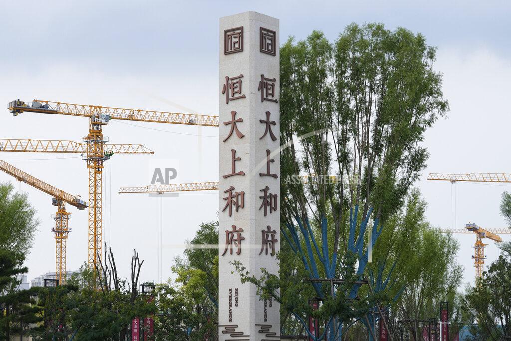 Andy Wong Construction cranes stand near the Evergrande's name and logo at its new housing development in Beijing, Wednesday, Sept. 15, 2021. One of China's biggest real estate developers is struggling to avoid defaulting on billions of dollars of debt, prompting concern about the broader economic impact and protests by apartment buyers about delays in completing projects. Rating agencies say Evergrande Group appears likely to be unable to repay all of the 572 billion yuan ($89 billion) it owes banks and other bondholders. That might jolt financial markets, but analysts say Beijing is likely to step in to prevent wider damage. (AP Photo/Andy Wong)
