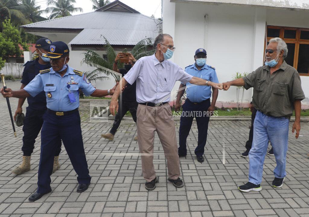 Raimundos Oki Xanana Gusmao, right, former East Timorese president and prime minister, gives a fist bump to Richard Daschbach, center, a defrocked priest originally from Pennsylvania accused of child abuse, after a hearing at a courthouse in Oecusse, East Timor, on Tuesday, Feb. 23, 2021. While he has his critics, Daschbach’s support appears deep and widespread, extending beyond Oecusse to the capital, Dili. It includes members of the political elite, including Gusmao _ also an independence hero. (AP Photo/Raimundos Oki)