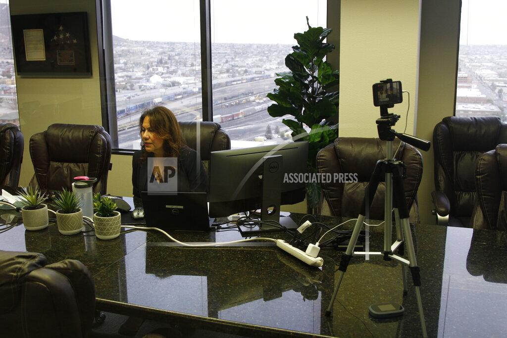 Cedar Attanasio In this Wednesday, March 18, 2020, photom Congresswoman Veronica Escobar, D-Texas, looks at a document while answering questions from constituents in a virtual town hall about the coronavirus in El Paso, Texas. Robo calls to homes around the district encouraged over 1,200 people to join the call to discuss the government's response to COVID-19. Escobar has closed her office to the public and moved all meetings to "no contact" to prevent spread of the virus. (AP Photo/Cedar Attanasio)