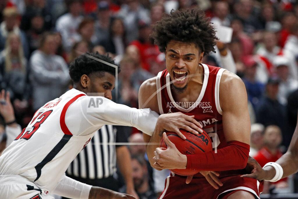 Brad Tollefson Texas Tech's Mylik Wilson (13) tries to steal the ball from Oklahoma's Ethan Chargois (15) during the first half of an NCAA college basketball game Tuesday, Feb. 22, 2022, in Lubbock, Texas. (AP Photo/Brad Tollefson)