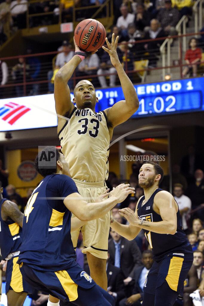Kathy Kmonicek Wofford forward Cameron Jackson (33) shoots over UNC-Greensboro forward Kyrin Galloway (14) and guard Demetrius Troy (11) in the first half of an NCAA college basketball game for the Southern Conference tournament championship, Monday, March 11, 2019, in Asheville, N.C. (AP Photo/Kathy Kmonicek)