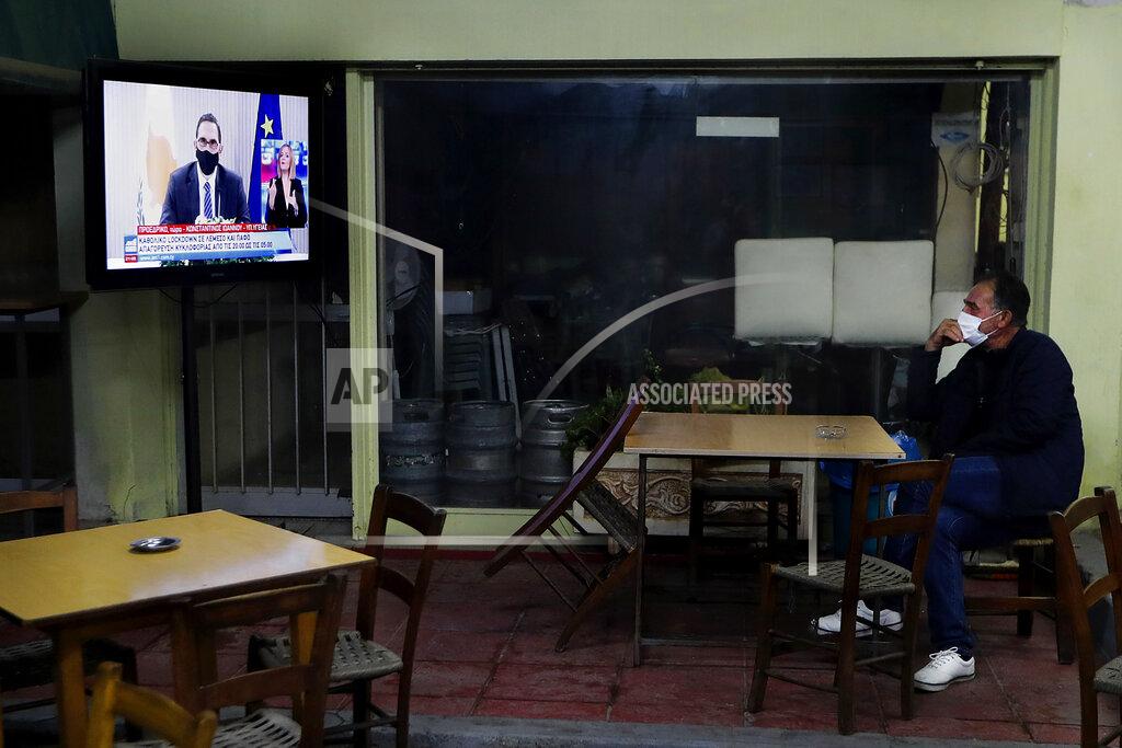 Petros Karadjias A Cypriot man sits at a social club and watch the televised address of Cyprus' Health Minister Constantinos Ioannou explaining the need for additional restrictions to beat back a surge in COVID-19 cases in Nicosia suburb of Lakatamia, Cyprus, on Tuesday, Nov. 11, 2020. Cyprus has put its entire southwest under a strict 19-day lockdown, banning any non-essential movement of people and shuttering bars and restaurants after a string of escalating restrictions failed to curb a sharp increase in COVID-19 infections. (AP Photo/Petros Karadjias)
