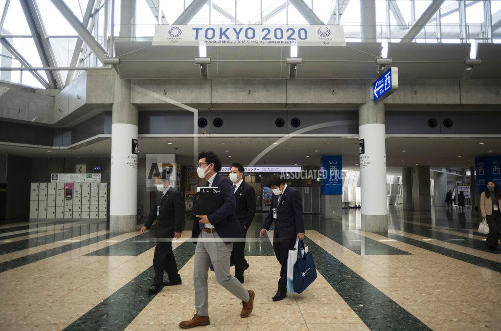 Hiro Komae People walk under a banner promoting the postponed Tokyo 2020 Olympic and Paralympic Games at the Tokyo International Exhibition Center, in Tokyo Thursday, April 8, 2021. The exhibition center, also known as Tokyo Big Sight, is a planned venue for the Tokyo 2020, rescheduled to start in July 2021. Many preparations are still up in the air as organizers try to figure out how to hold the postponed games in the middle of a pandemic. (AP Photo/Hiro Komae)