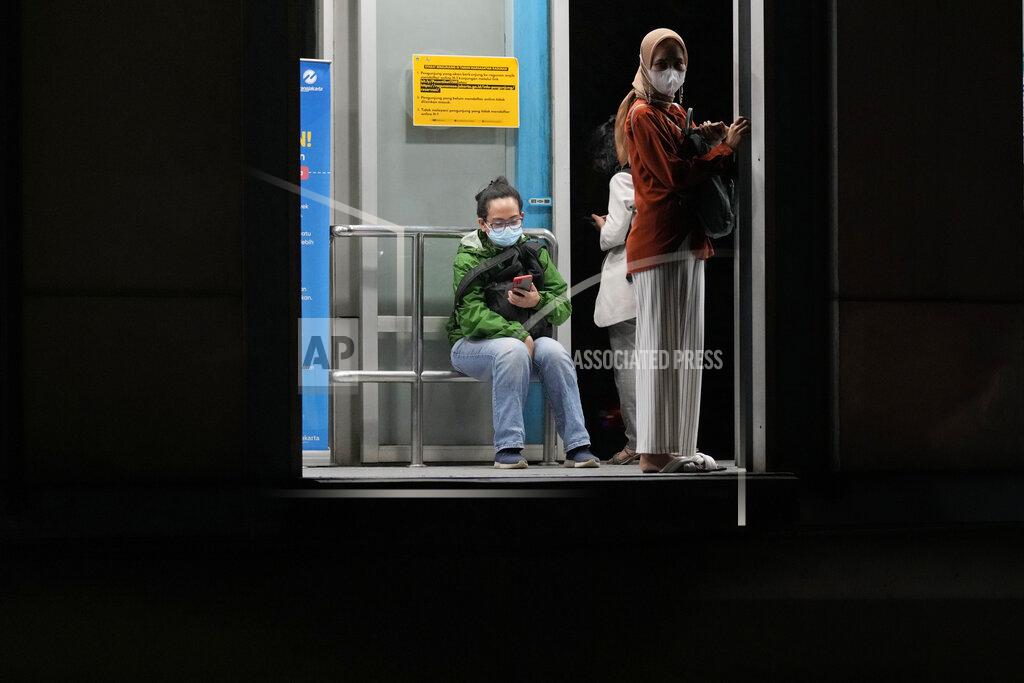 Dita Alangkara People wearing masks to curb the spread of the coronavirus wait at a bus stop in Jakarta, Indonesia, Tuesday, May 17, 2022. Indonesia will lift its outdoor mask mandate because its COVID-19 outbreak appears to be waning, President Joko Widodo said Tuesday. (AP Photo/Dita Alangkara)