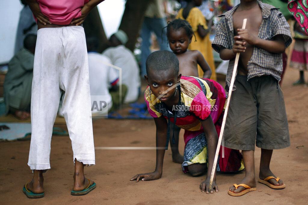 Jerome Delay FILE - In this April 14, 2014 file photo, Hamamatou Harouna, 10, who lost the use of her legs to polio, crawls to the restroom on the grounds of the Catholic Church where she and hundreds of others found refuge after fleeing violence in her village, in Carnot, Central African Republic. Health authorities on Tuesday, Aug. 25, 2020 are expected to declare the African continent free of the wild poliovirus after decades of effort, though cases of vaccine-derived polio are still sparking outbreaks of the paralyzing disease in more than a dozen countries. (AP Photo/Jerome Delay, File)