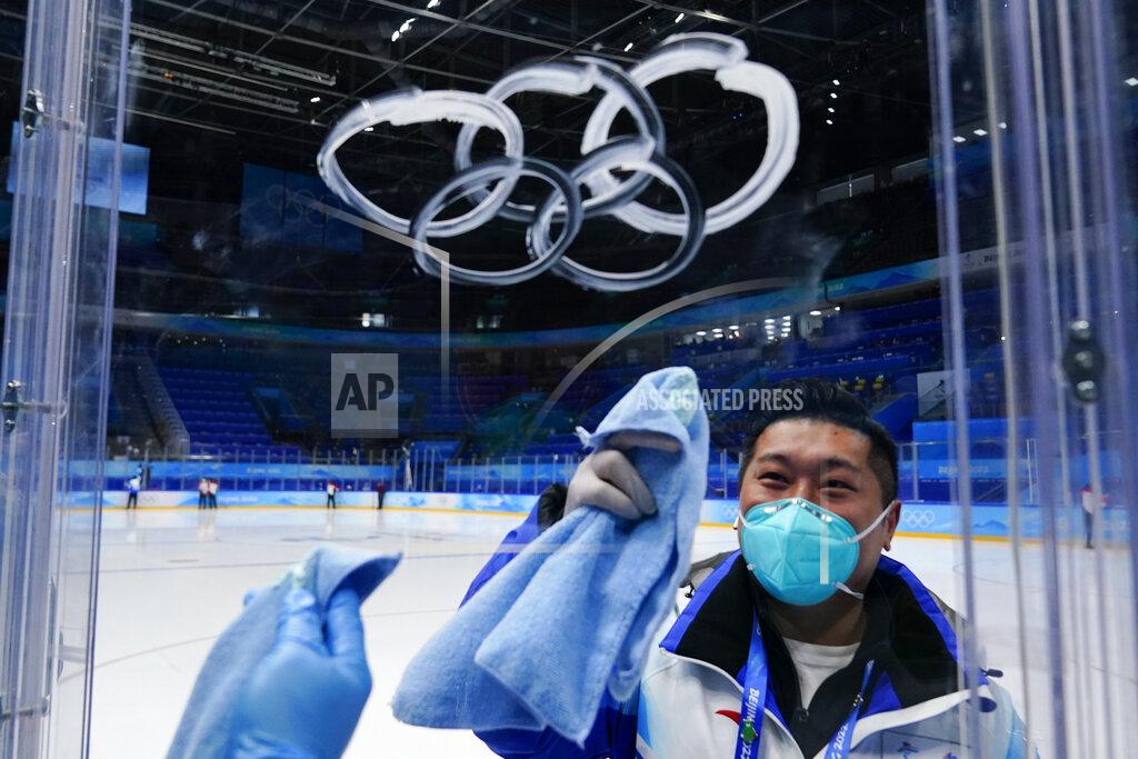 Matt Slocum A worker sprays the Olympic rings with cleaner as he cleans the glass around the ice before the men's gold medal hockey game between Finland and Russian Olympic Committee at the 2022 Winter Olympics, Sunday, Feb. 20, 2022, in Beijing. (AP Photo/Matt Slocum)
