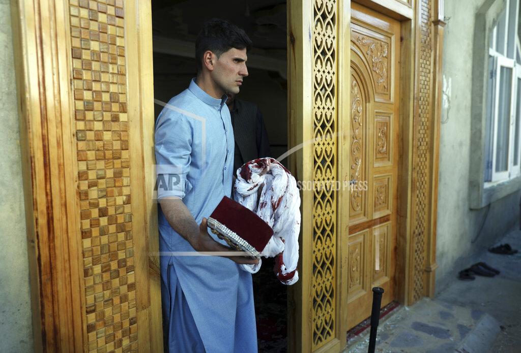 Rahmat Gul An Afghan man holds a blood-stained turban and cap inside a mosque after a bomb explosion in Shakar Dara district of Kabul, Afghanistan, Friday, May 14, 2021. A bomb ripped through a mosque in northern Kabul during Friday prayers killing 12 worshippers, Afghan police said. (AP Photo/Rahmat Gul)