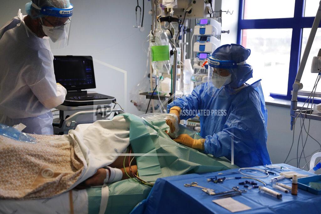 Armando Franca A doctor performs an ultrasound scan on a patient in a COVID-19 Intensive Care Unit at the Curry Cabral hospital in Lisbon, Thursday, Feb. 11, 2021. After Portugal figured for about two weeks last month as the world’s worst-hit country by size of population, anxiety over the recent pandemic peak has eased slightly. The number of COVID-19 patients in hospital and in intensive care fell Thursday for the third straight day. The health ministry reported the fewest hospitalizations since Jan. 20 and the fewest patients in ICUs for almost two weeks. (AP Photo/Armando Franca)