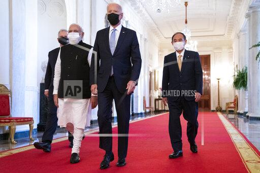 President Joe Biden walks to the Quad summit with, from left, Australian Prime Minister Scott Morrison, Indian Prime Minister Narendra Modi, and Japanese Prime Minister Yoshihide Suga, in the East Room of the White House, Friday, Sept. 24, 2021, in Washington. (AP Photo/Evan Vucci)