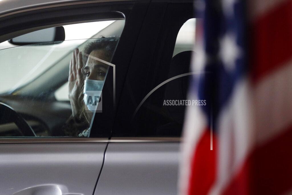 Carlos Osorio FILE- In this June 26, 2020, file photo, Anita Rosenberger takes the oath of citizenship during a drive-thru naturalization service in a parking structure at the U.S. Citizenship and Immigration Services headquarters on Detroit's east side. U.S. Citizenship and Immigration Services has transformed under President Donald Trump to emphasize fraud detection, enforcement and vetting, which has delayed processing and contributed to severe fiscal problems. Its revamp came as the administration sought to cut legal immigration by making it more dependent on employment skills and wealth tests. (AP Photo/Carlos Osorio, File)